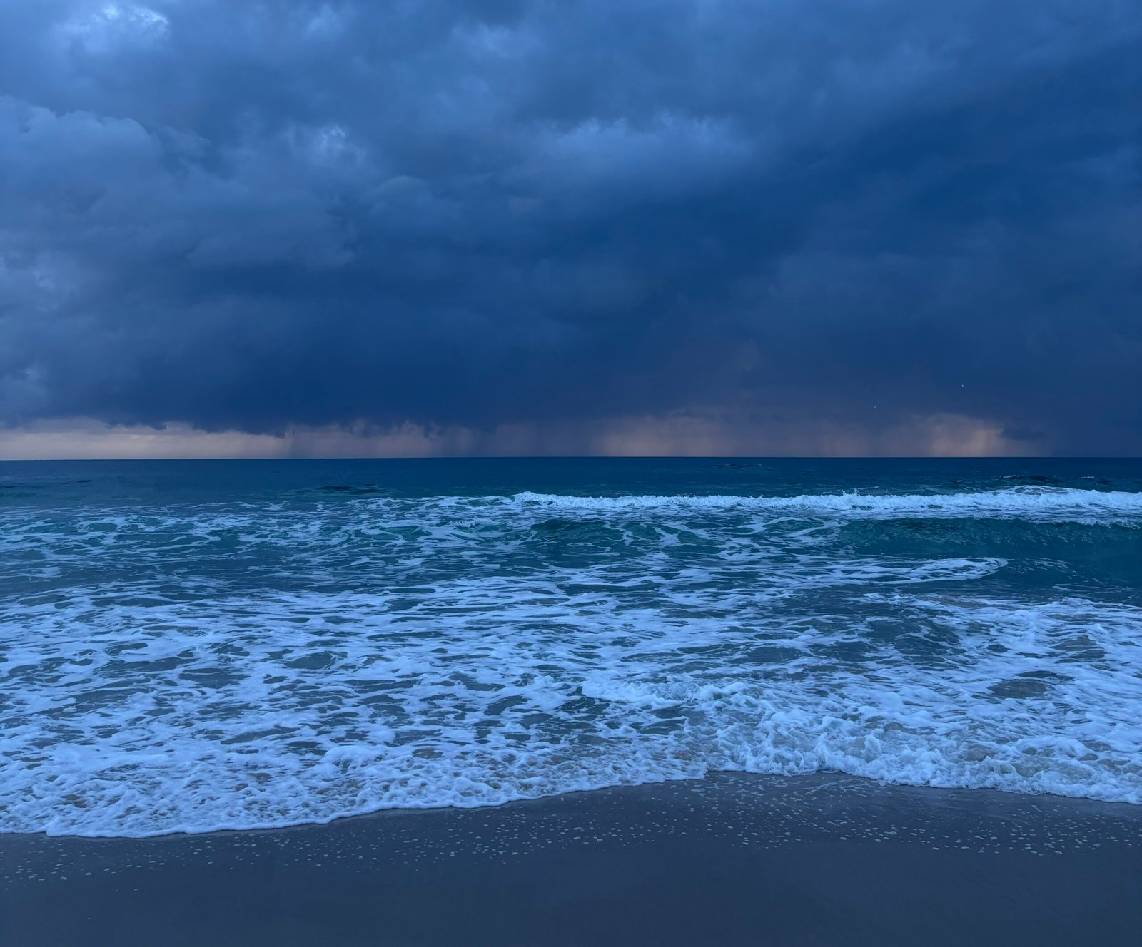 Storm clouds over the ocean, symbolising the heaviness and intensity often felt during depression, with a glimpse of light on the horizon suggesting hope and change.