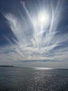 Gender differences in thought and emotion | Sunlight over a calm ocean with wispy clouds stretching across the blue sky, symbolising reflection, balance, and the shared human experience of thought and emotion.