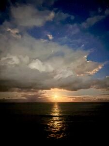 Moonlight reflecting across the ocean beneath a cloudy night sky, symbolising taking space, calming emotions, and using DBT skills before responding to conflict.