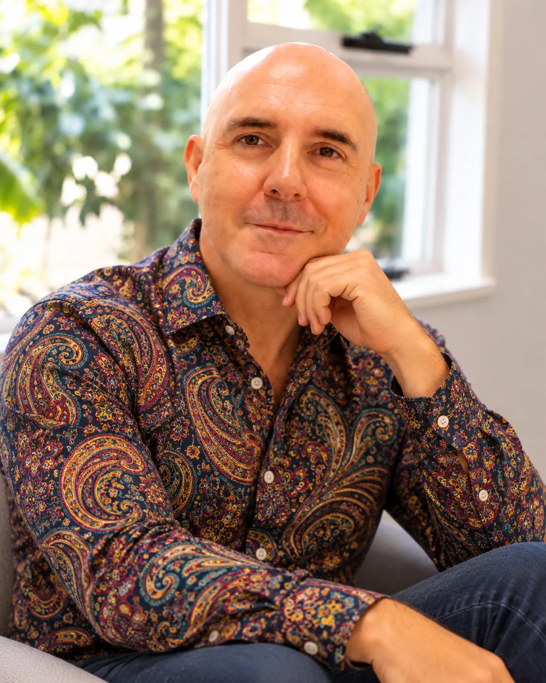 David Hennessy, Clinical Psychologist, seated in a colourful paisley shirt.